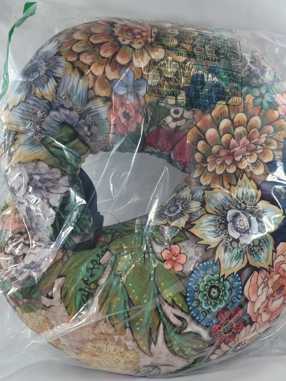 C-shaped nursing pillow featuring a vibrant, bohemian floral pattern